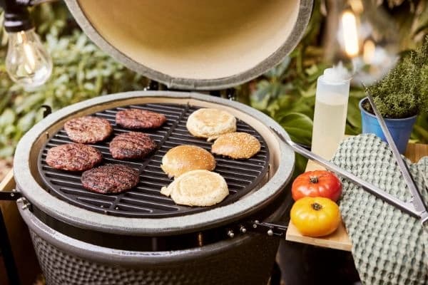 Gratar Gill Guru Original Medium cu capacul deschis si bucati de carne si chifla pe gril.